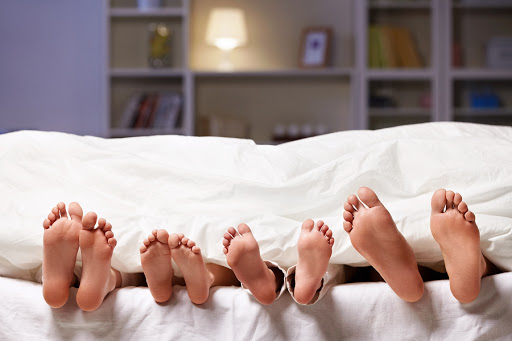 family feet at the end of the bed