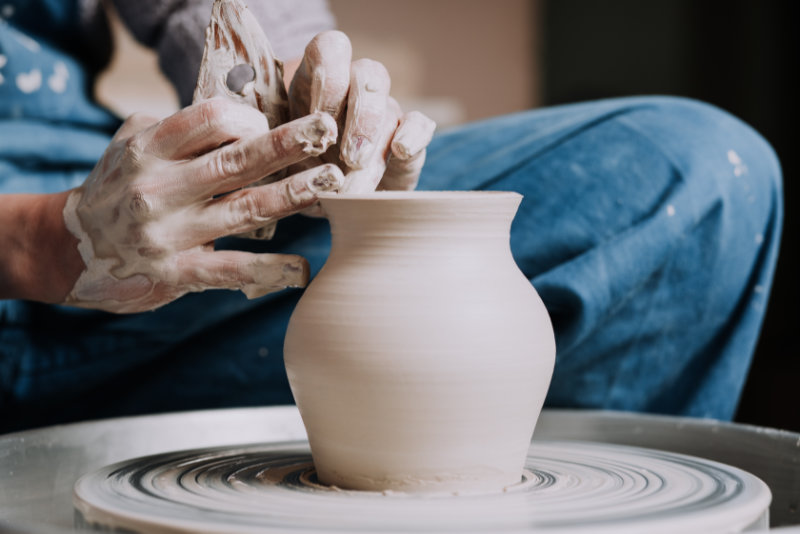 Close-up on woman hands creating handmade ceramic vase in a pottery. Creative workshop.