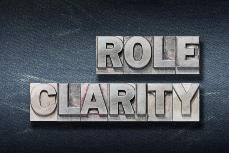 role clarity phrase made from metallic letterpress on dark jeans background